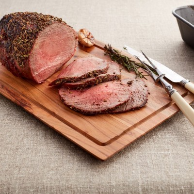 Herb crusted roast Welsh Beef carved on a board