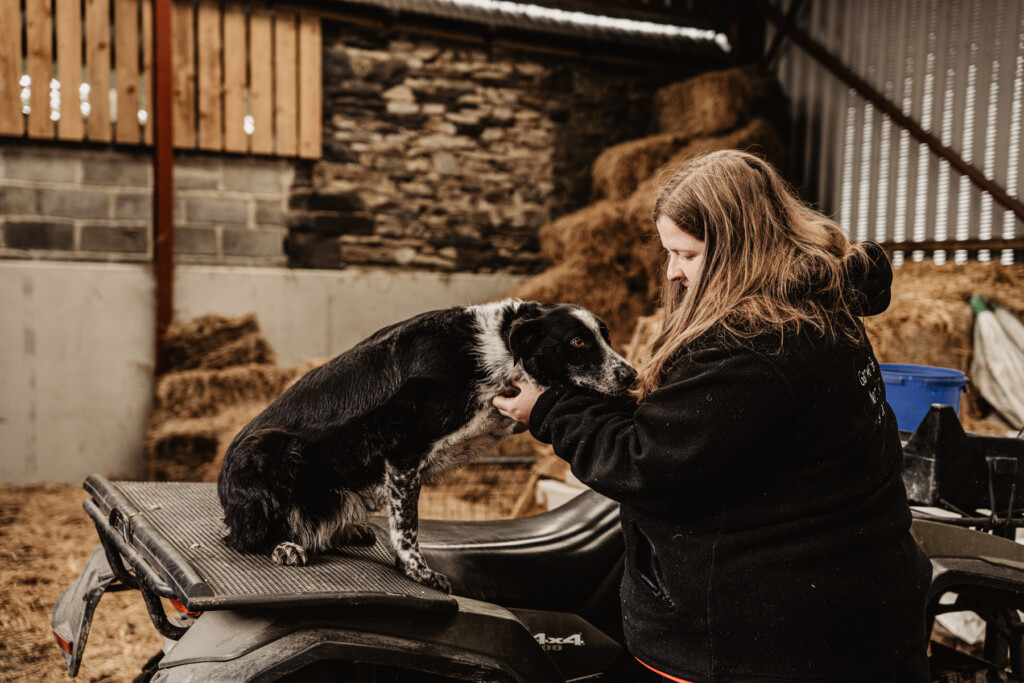 Emily with her trusty sheepdog sitting on her quadbike