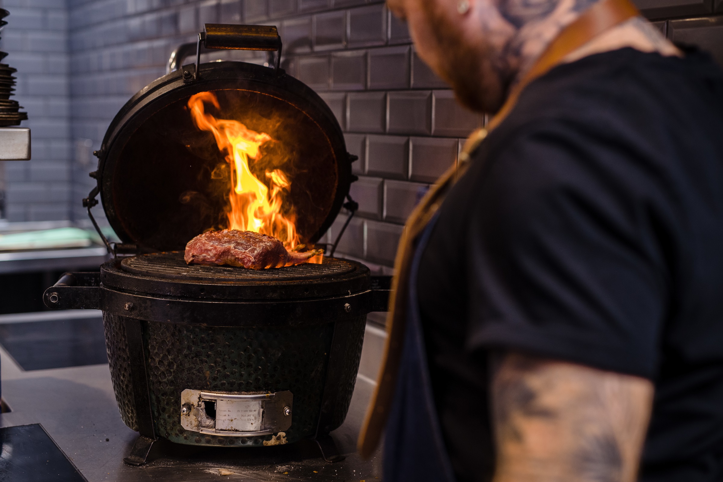 Chef Tommy Heaney cooking a Welsh Lamb rack over flames 